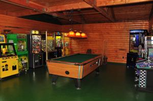Douglas CenterArrowhead Camping Resort Deluxe Cabin 14的一间带台球桌和数台游戏机的房间