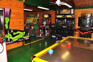 Douglas Center阿罗黑德露营10号假日公园的游戏室设有桌子和街机游戏