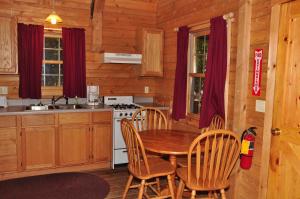 斯特金贝Tranquil Timbers Deluxe Cabin 6的小屋内的厨房配有桌椅