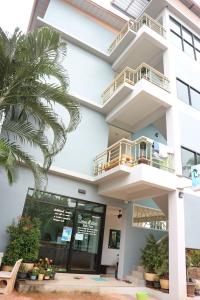 涛岛清凉生活高涛岛酒店的一座白色的建筑,前面有棕榈树