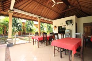 蓝梦岛捷鹏巴厘岛别墅 的一间用餐室,配有红色的桌子和椅子