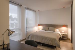 波哥大ZITU 106的一间卧室设有一张床和一个大窗户