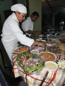 Rodrigues Island庞达努斯旅馆 的厨师在餐桌上准备食物,配以各种食物