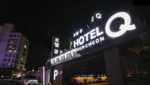 春川春川Q酒店的夜间酒店顶上的标志