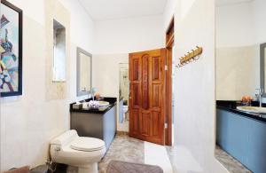 圣吉吉水果别墅酒店的一间带卫生间和水槽的浴室以及一扇木门。
