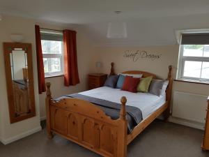 TimsburyThe Annexe的一间卧室设有木床和2个窗户。
