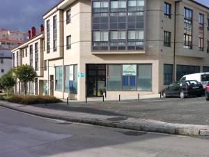 圣地亚哥－德孔波斯特拉嘉居旅游旅舍的街道上的建筑物,前面有车辆停放