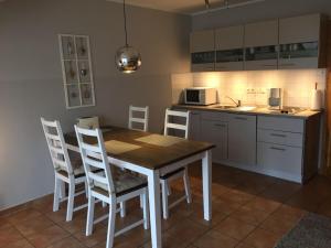 格洛韦Ferienwohnung Möwe的厨房配有木桌和白色椅子
