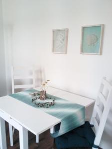 威廉港Monteur & Fewo Sealoft的一张白色的餐桌,上面有蓝色的桌布