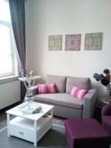 威廉港Monteur & Fewo Sealoft的客厅配有灰色的沙发和粉红色的枕头。