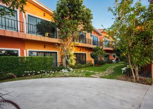 呵叻萨塔别墅精品度假村 的一座橙色公寓楼,设有圆形车道