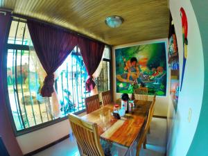 莱蒂西亚Hostal La Esperanza的一间带木桌和窗户的用餐室