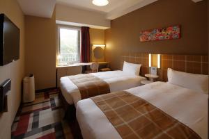 神户神户蒙特埃马纳酒店・艾美丽的酒店客房设有两张床和电视。