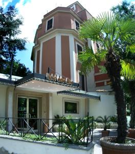 罗马德尔缪斯酒店的前面有棕榈树的建筑