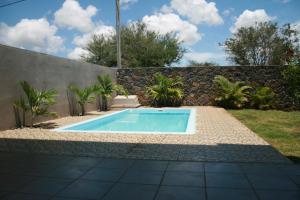 特鲁欧克比赫斯Happy Villa的一座带石墙的花园内的游泳池