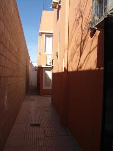 Las PerdicesNec Apart Hotel的一条小巷,有一座建筑和砖墙