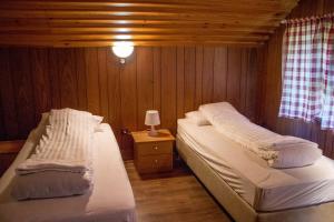 GerdiOld Cottage - Reynivellir II的一间卧室配有两张床和一张带台灯的桌子