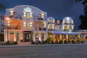 奥斯赛拜-屈隆斯博恩库伦斯伯恩最大海滩酒店的一座白色的大建筑,外墙有灯光