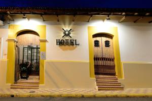 莱昂Hotel La Posada del Doctor的一座建筑,上面有两扇门和酒店标志