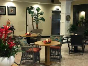 阿罕布拉GreenTree Inn & Suites Los Angeles - Alhambra - Pasadena的一间设有两张桌子和椅子的餐厅,种植了植物