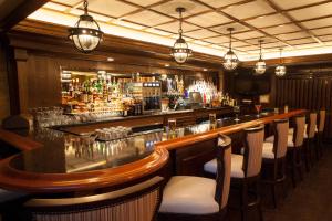 戴德伍德富兰克林历史酒店的一间酒吧,里面设有长柜台和椅子