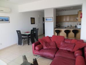 帕福斯Melania Apartment的一间带红色沙发的客厅和一间厨房