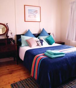卡斯尔梅恩考卡布瑞度假屋的一间卧室配有一张带蓝色床单和枕头的床。