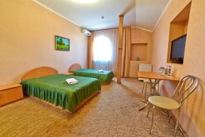 基辅三角洲酒店的酒店客房设有两张床和一张桌子。