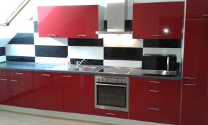 哈根Monteur Apartment Charlotte的红色的厨房,配有红色橱柜和水槽