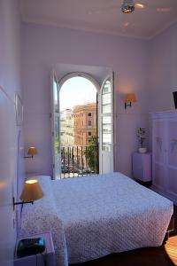 罗马Lilium Boutique Hotel的一间卧室设有一张大床和一个大窗户