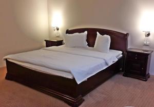 福克沙尼Green Park Boutique Hotel的卧室配有一张带白色床单和枕头的大床。