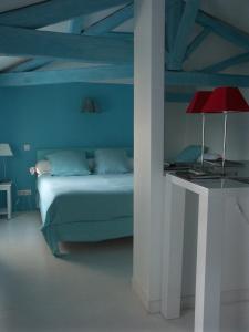 昂古莱姆帕莱斯酒店的蓝色卧室,配有床和红灯