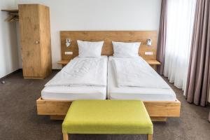 比登科普夫Lahn Hotel的一间卧室设有两张床和绿色长凳