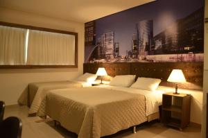 奥托兰迪亚Hotel HortoPlaza的两张位于酒店客房的床,墙上挂着照片