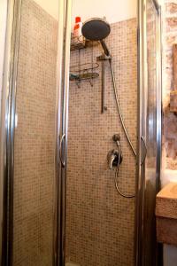 奥斯图尼梦之家公寓的浴室里设有玻璃门淋浴