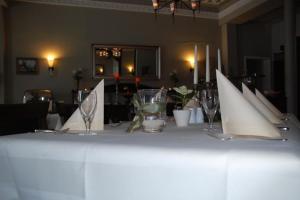 博尔滕哈根Gutshaus Redewisch Hotel & Restaurant的一张带酒杯和餐巾的白色桌子