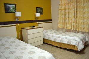 圣赫尔曼Hostal Universitario的带两张床和梳妆台的房间