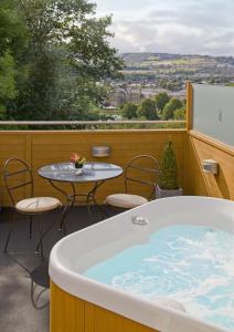 因弗内斯Rocpool Reserve Luxury Highland Package的庭院内的热水浴池,配有桌椅