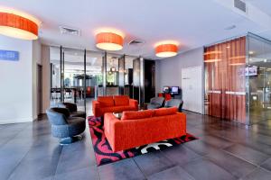 达尔文潘达纳斯曼特拉酒店的客厅配有橙色家具和椅子