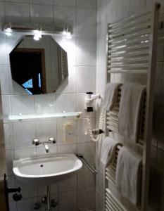 WehingenHotel Heuberger Hof, Wehingen的浴室配有盥洗盆、镜子和毛巾