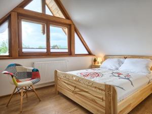 扎科帕内Willa Mnich的一间卧室配有一张床、一把椅子和窗户。