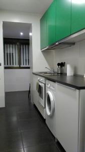 马德里Madrid Rent 3的厨房配有洗衣机和绿色橱柜。