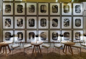 巴塞罗那H10卡萨含羞草4*索普酒店的一间设有桌椅的房间,位于墙上,配有图片
