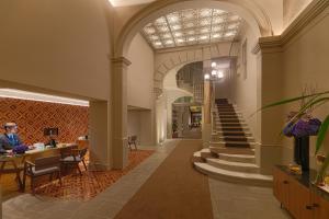 巴塞罗那H10卡萨含羞草4*索普酒店的大厅,有楼梯,有人坐在桌子上