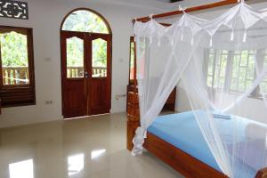 武吉拉旺猩猩酒店的一间卧室配有一张带天蓬的床