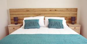 蓬塔阿雷纳斯耐力公寓式酒店的一张带两个蓝色枕头的床和两个床头柜