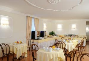 罗马托瑞诺酒店的用餐室配有桌椅和白色桌布