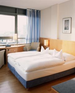 汉堡巴塞尔酒店的酒店客房设有一张大床和一张书桌。