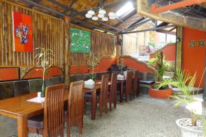 武吉拉旺猩猩酒店的餐厅设有木桌和椅子,种有植物