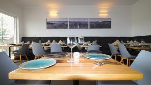 巴特曼斯贝码头酒店的一张木桌,上面放有盘子和酒杯